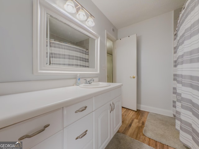 2610 Cumberland Ct, Smyrna, GA 30080 - bathroom with wood finished floors, vanity, baseboards, and a shower with shower curtain