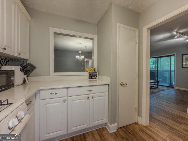 2610 Cumberland Ct, Smyrna, GA 30080 - bar area featuring dark wood finished floors, gas range oven, a chandelier, black microwave, and baseboards