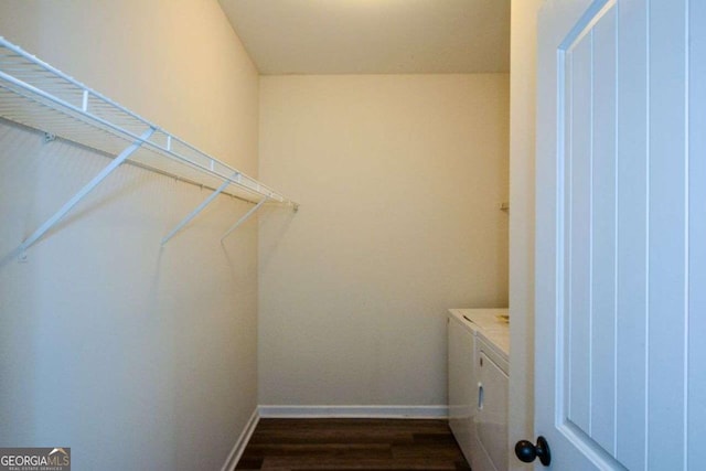 laundry area with washer and dryer, dark wood finished floors, and baseboards