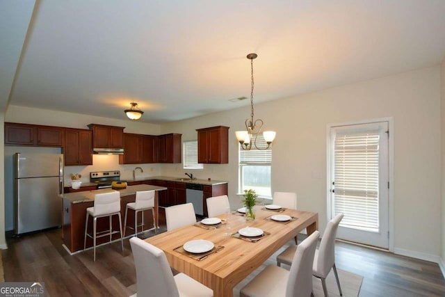 dining area with dark wood-type flooring and a chandelier