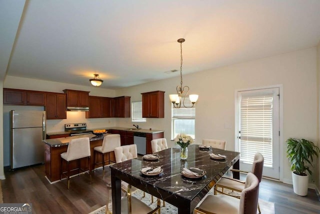 dining space featuring dark wood-style floors and a chandelier
