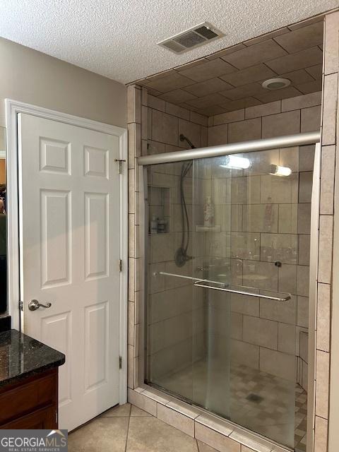 1009 Hunters Pointe Dr, Statesboro, GA 30461 - full bathroom featuring tile patterned floors, a stall shower, a textured ceiling, and vanity