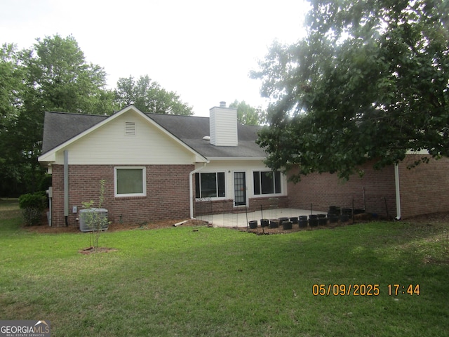1009 Hunters Pointe Dr, Statesboro, GA 30461 - back of house featuring brick siding, central AC unit, a yard, a patio area, and a chimney