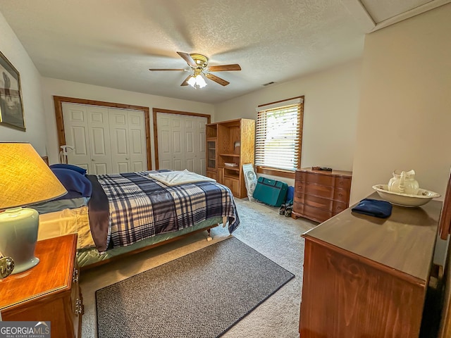 30 Putter Ln, Dillard, GA 30537 - carpeted bedroom featuring multiple closets, a ceiling fan, and a textured ceiling