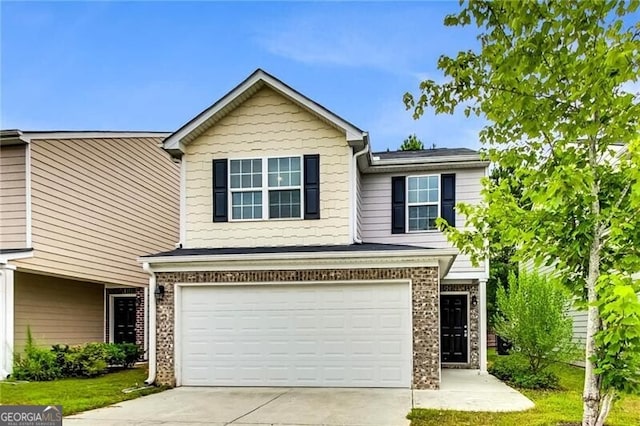 view of front of house featuring a garage, concrete driveway, brick siding, and a front lawn