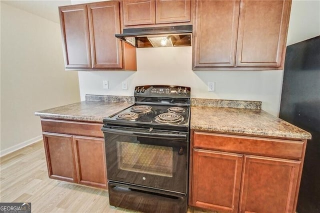 kitchen with black appliances, under cabinet range hood, light wood-style floors, and baseboards