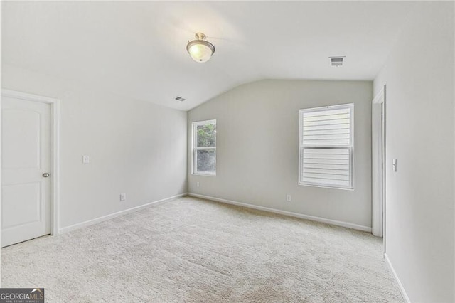 unfurnished room featuring lofted ceiling, carpet, and baseboards