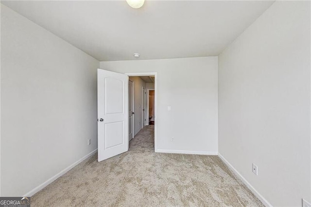 carpeted spare room with baseboards