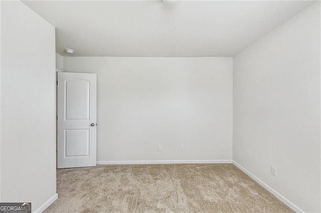 unfurnished room featuring carpet and baseboards