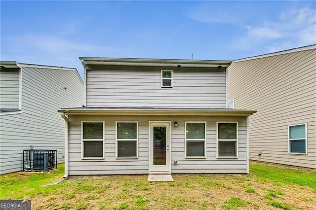 back of house featuring central AC and a yard