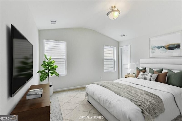 bedroom with vaulted ceiling, light colored carpet, and baseboards