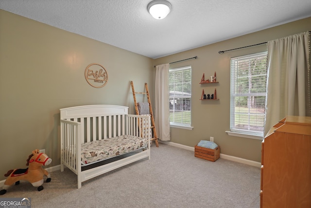 142 Dawn Cir, Brunswick, GA 31523 - carpeted bedroom featuring multiple windows, baseboards, a crib, and a textured ceiling