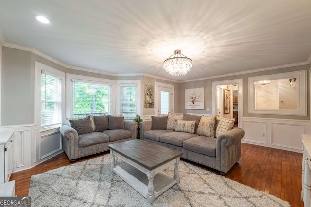 living area featuring a decorative wall, a chandelier, wood-type flooring, crown molding, and a wainscoted wall