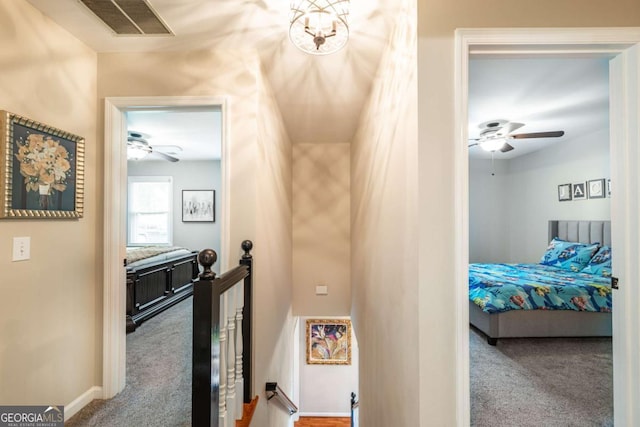 corridor with an upstairs landing, carpet floors, and baseboards