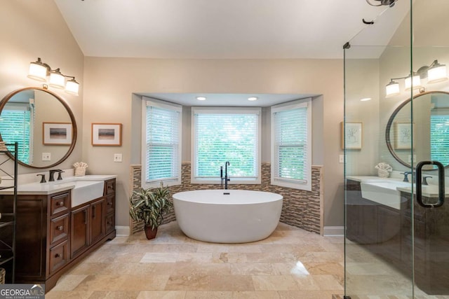 bathroom featuring vanity, lofted ceiling, a freestanding bath, baseboards, and a shower stall