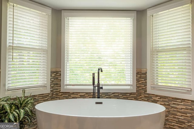full bath featuring a sink, a soaking tub, and tile walls