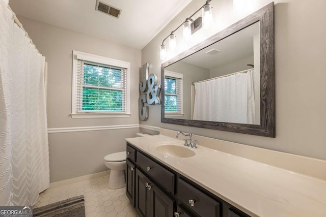 bathroom featuring toilet, vanity, tile patterned floors, baseboards, and a shower with shower curtain