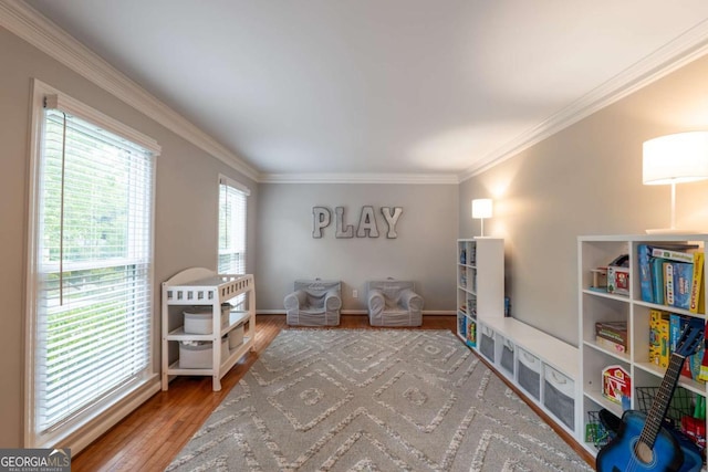 sitting room with wood finished floors, crown molding, and baseboards