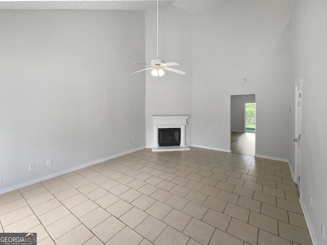 5480 Walnut Ln, Lithonia, GA 30038 - unfurnished living room with a high ceiling, a ceiling fan, a glass covered fireplace, and light tile patterned flooring