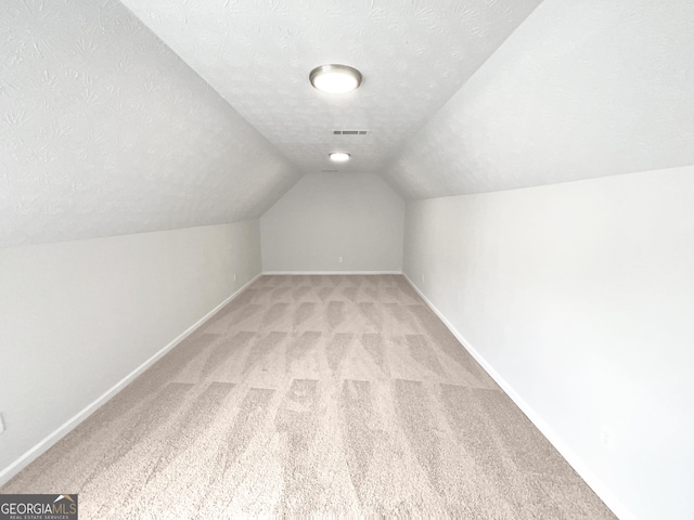 5480 Walnut Ln, Lithonia, GA 30038 - bonus room featuring light colored carpet, lofted ceiling, and a textured ceiling