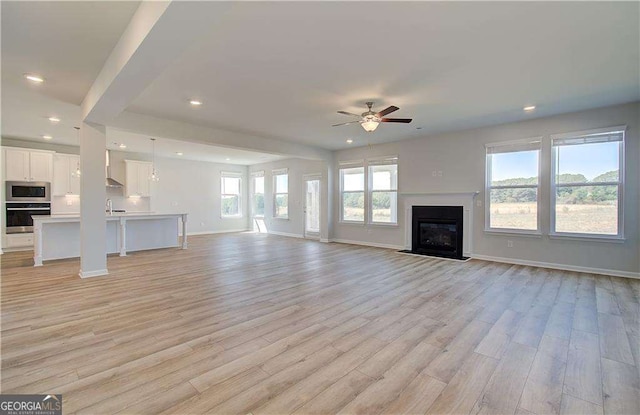 612 Sidney Ct, Stockbridge, GA 30281 - unfurnished living room with a ceiling fan, light wood-type flooring, recessed lighting, a fireplace with flush hearth, and baseboards