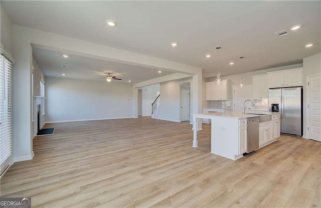 612 Sidney Ct, Stockbridge, GA 30281 - kitchen featuring appliances with stainless steel finishes, light countertops, a sink, light wood finished floors, and recessed lighting
