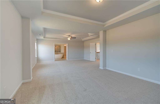 612 Sidney Ct, Stockbridge, GA 30281 - empty room with light colored carpet, a ceiling fan, a tray ceiling, baseboards, and ornamental molding