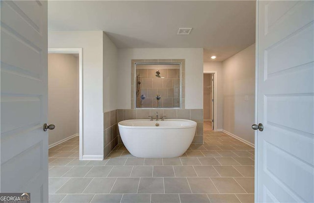 612 Sidney Ct, Stockbridge, GA 30281 - full bath featuring a soaking tub, tile patterned flooring, tiled shower, and baseboards
