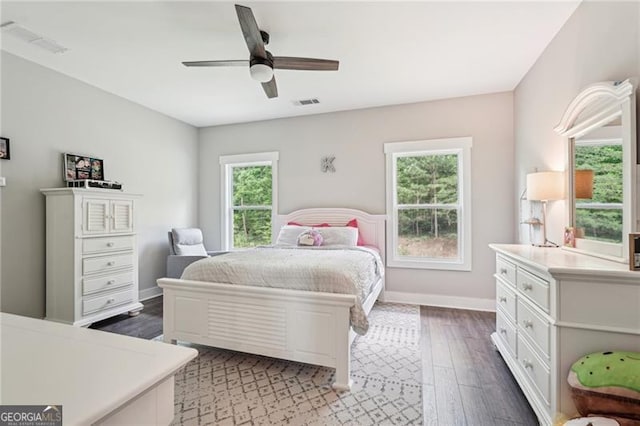 bedroom with multiple windows, wood finished floors, baseboards, and ceiling fan