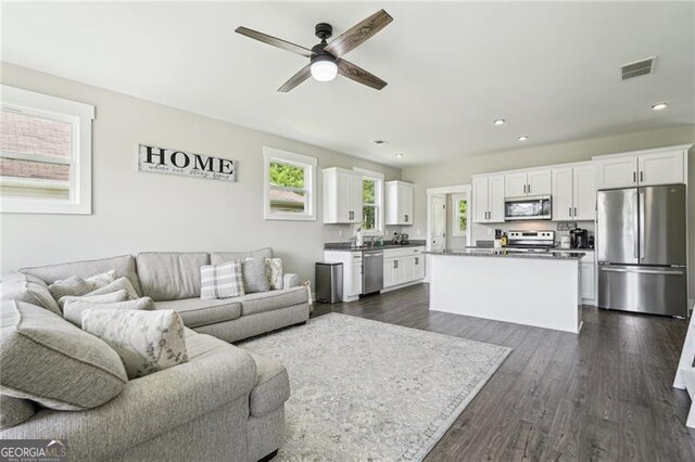 living room with plenty of natural light, ceiling fan, dark wood-style flooring, and recessed lighting