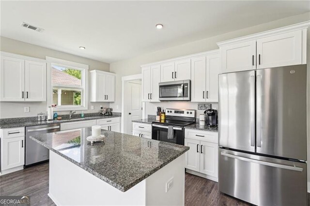 166 Wagon Trail Cir, Fairmount, GA 30139 - kitchen featuring stainless steel appliances, white cabinetry, a kitchen island, dark stone counters, and dark wood-style flooring