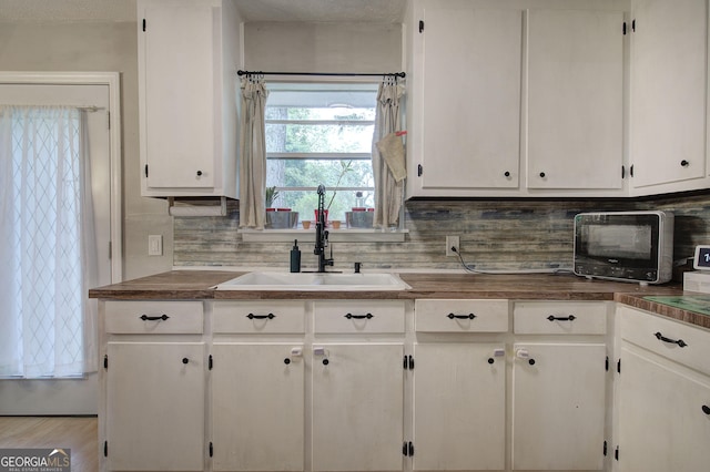 7 Valley View Dr, Cartersville, GA 30120 - kitchen featuring decorative backsplash, white cabinets, and dark countertops