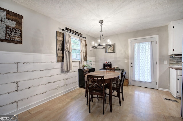 7 Valley View Dr, Cartersville, GA 30120 - dining space featuring light wood-type flooring, a chandelier, a textured ceiling, and a wainscoted wall