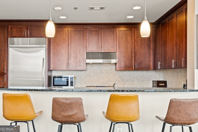 270 17th St NW Unit 1113, Atlanta, GA 30363 - kitchen with under cabinet range hood, appliances with stainless steel finishes, dark stone countertops, backsplash, and recessed lighting