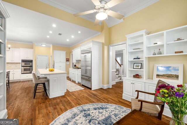 626 Kimberly Ln NE, Atlanta, GA 30306 - kitchen featuring appliances with stainless steel finishes, ornamental molding, wood finished floors, decorative backsplash, and white cabinetry
