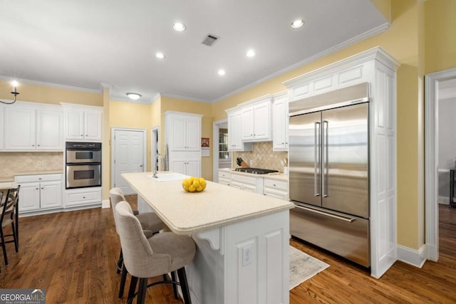 626 Kimberly Ln NE, Atlanta, GA 30306 - kitchen with appliances with stainless steel finishes, white cabinets, decorative backsplash, ornamental molding, and recessed lighting