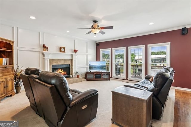 living area with a ceiling fan, a fireplace, ornamental molding, and recessed lighting