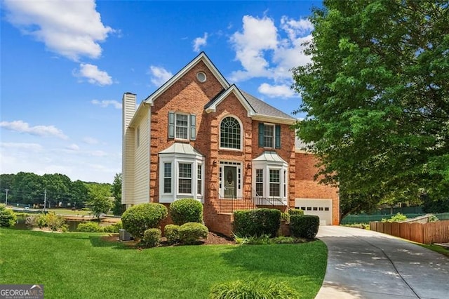view of front of property with concrete driveway, a chimney, brick siding, and a garage
