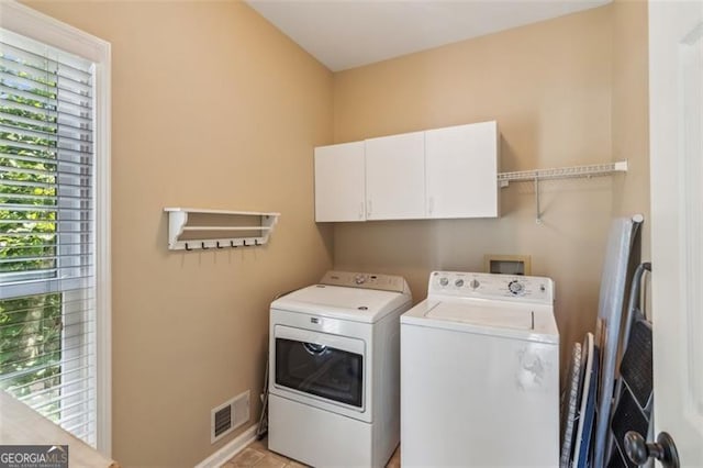 laundry room featuring washer and clothes dryer, cabinet space, and baseboards