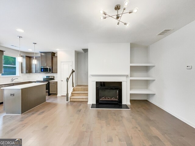 4922 Longview Walk, Decatur, GA 30035 - unfurnished living room featuring light wood-type flooring, stairs, a chandelier, and a fireplace