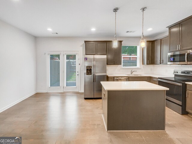 4922 Longview Walk, Decatur, GA 30035 - kitchen featuring stainless steel appliances, decorative backsplash, a center island, dark brown cabinets, and light countertops