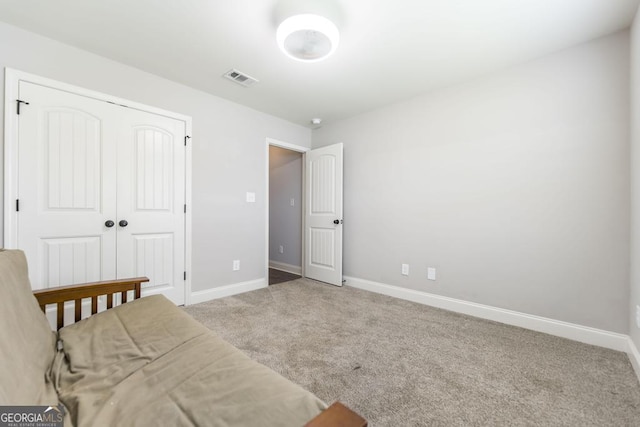 carpeted bedroom featuring baseboards and a closet