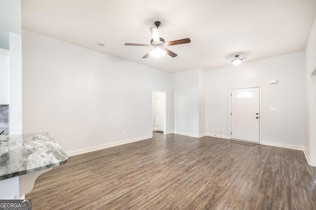 unfurnished living room with a ceiling fan, wood finished floors, and baseboards
