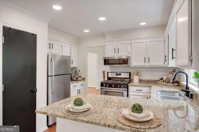 1380 Heritage Glen Dr, Marietta, GA 30068 - kitchen featuring stainless steel appliances, a sink, a peninsula, light stone counters, and white cabinets