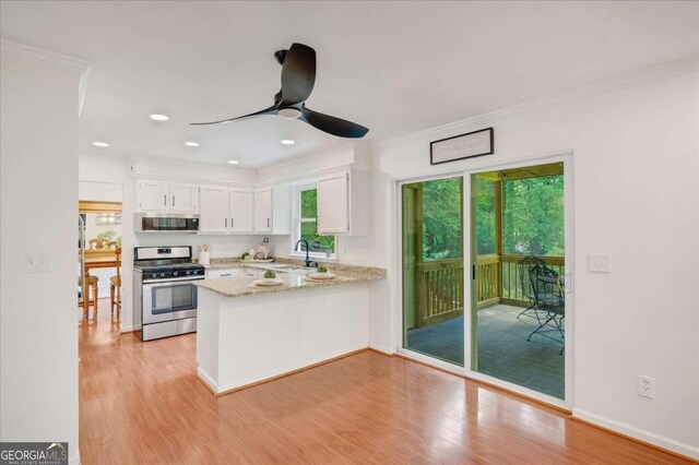 1380 Heritage Glen Dr, Marietta, GA 30068 - kitchen featuring stainless steel appliances, a peninsula, white cabinetry, a ceiling fan, and light wood-style flooring