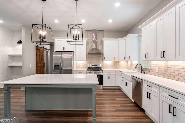 kitchen with stainless steel appliances, wall chimney range hood, a sink, a kitchen island, and dark wood-type flooring