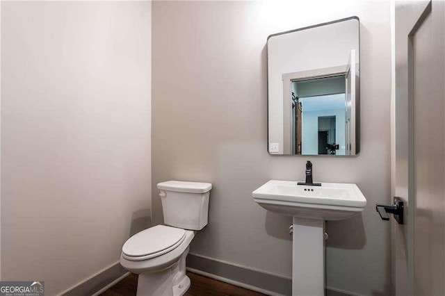 half bathroom with toilet and baseboards
