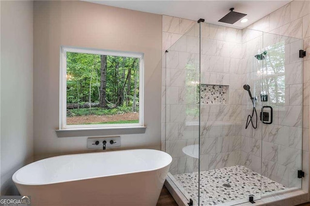 full bath featuring a stall shower and a freestanding tub