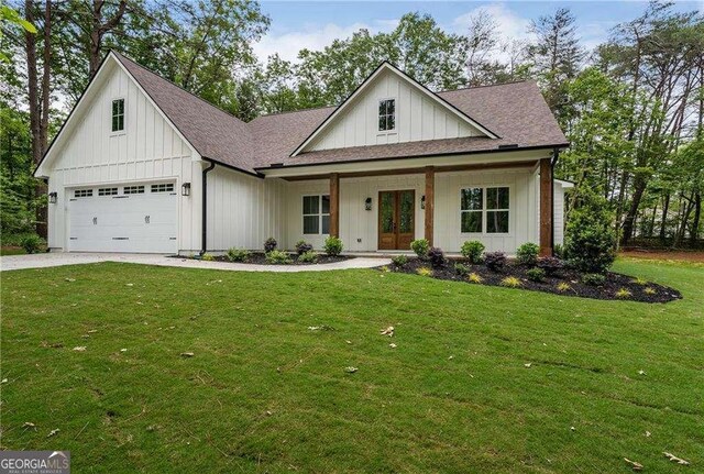 modern farmhouse style home featuring french doors, board and batten siding, a garage, and driveway