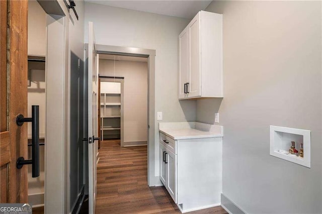 laundry area with cabinet space, washer hookup, dark wood-style flooring, and baseboards